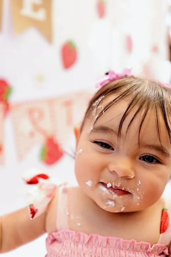 Cake smash close up with frosting on her cheeks