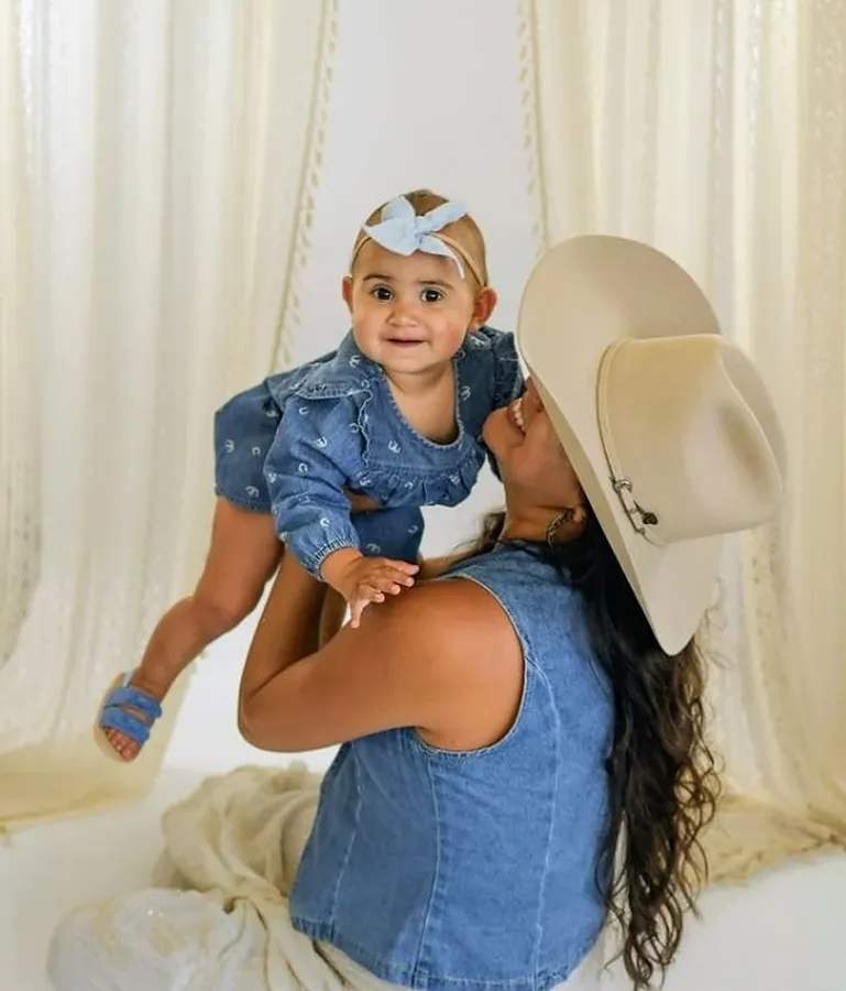 Mother lifting her baby girl up during a denim session
