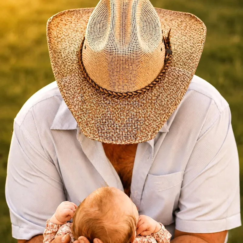 Father cradling his newborn at golden hour